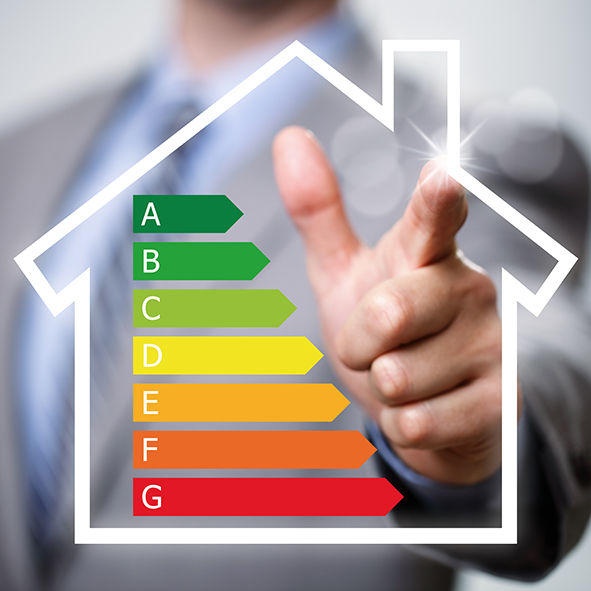 Empresario señalando el gráfico de calificación de eficiencia energética y el concepto de icono de casa para el rendimiento, la eficiencia y la conservación del medio ambiente